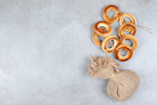A tied ring of sushki and a sack on marble background