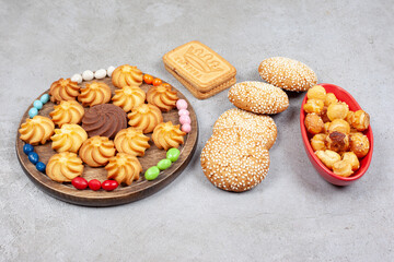 An assortment of cookies and biscuits with candies on marble background