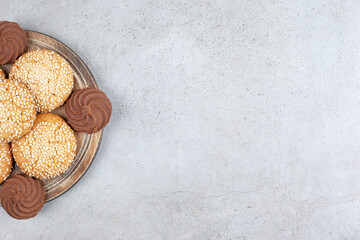 Cookies neatly stacked on a wooden board on marble background
