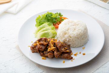Stir-Fried Pork with Garlic and pepper with cooked thai jasmine rice in white plate,popular Thai Street food