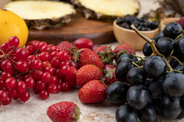 Assortment of various fruits on wooden board and marble background