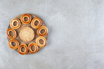 Single cookie surrounded by sushki on a wooden board on marble background
