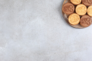 Decorated cookies on wooden board in marble background