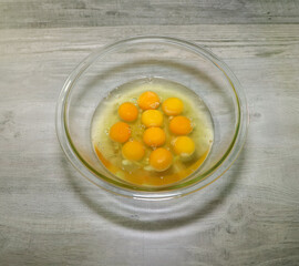 Ten full eggs in a glass bowl.