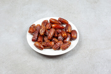 Dates on a white plate on marble background