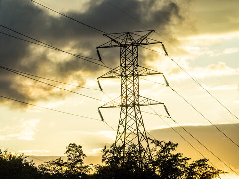 Power tower with power lines against dark clouds 