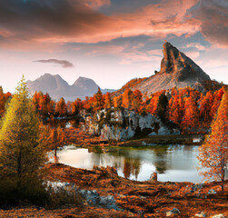Majestätischer Sonnenuntergang der Berglandschaft. Wunderbare Naturlandschaft während des Sonnenuntergangs. Wunderschön gefärbte Bäume über dem Federa-See, die im Sonnenlicht leuchten © Milos