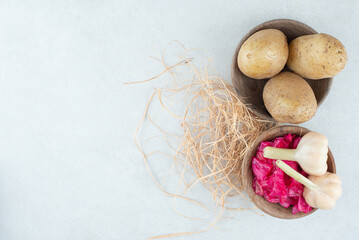 Bowls of boiled potatoes and pickled red cabbage with garlic