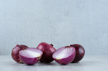 Fresh red onions on stone surface