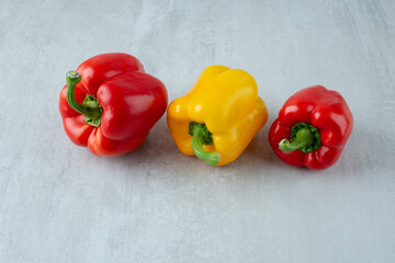 Red and yellow bell peppers on stone background