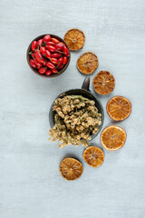 Bowl of rosehips, dried orange and rue on stone surface