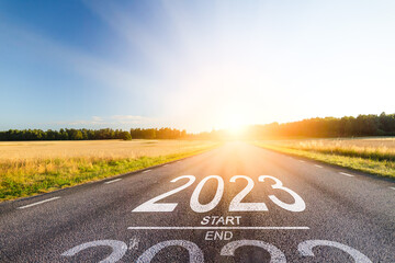 New year 2023 start straight concept. Word 2023 written in the middle of an asphalt road at sunset....
