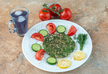 A white plate with vegetables and cup of juice