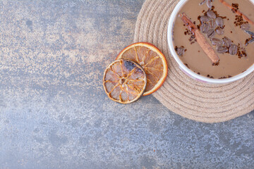 Fototapeta na wymiar Cup of milk coffee with cinnamon sticks and orange slices