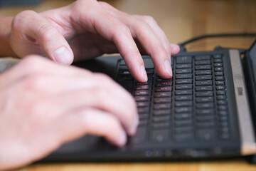 Person typing on laptop closeup