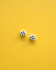 Yellow Background With White-Black Dice. Simple Minimalist Composition with Two Dice with Six Dots on Each. No Text. Symbol of Gambling or Big Luck.