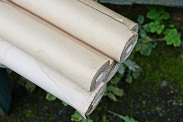 pile of gray white paper rolls of wallpaper on the street
