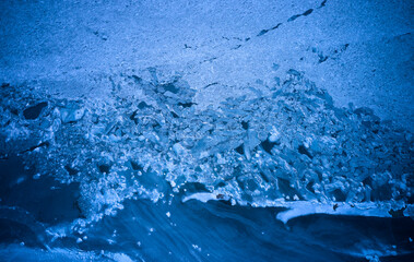 Aerial top view from above of frozen sea glaciers at the beach. Cracked ice floes in ocean on...