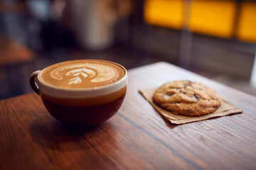 Close Up Of Decorated Coffee And Cookie On Table In Coffee Shop