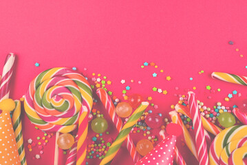 Colorful candies on a red  background. Lollipop. Top view. Copy space.