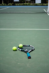 Dos bolas de tenis y raqueta en la cancha