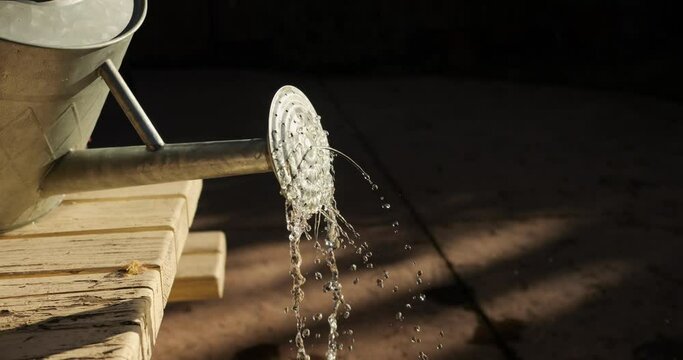 Water dripping out of watering can in slow motion 