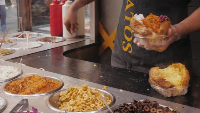 Mexican Turkish style baked potatoes, kumpir with meat Chili con carne filling and cheese, traditional Istanbul street food.
