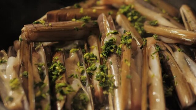 Razor clams seafood grilled on market, grill Spanish Navajas, traditional food in Spain, Catalonia, Barcelona.