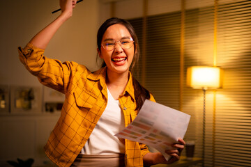 Young beautiful woman in yellow shirt work late from home in living room at late night...