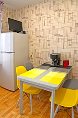Fototapeta na wymiar Kitchen interior with fridge and yellow chairs