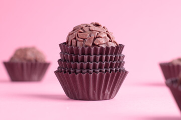 Brigadeiro em forma marrom sobre fundo rosa