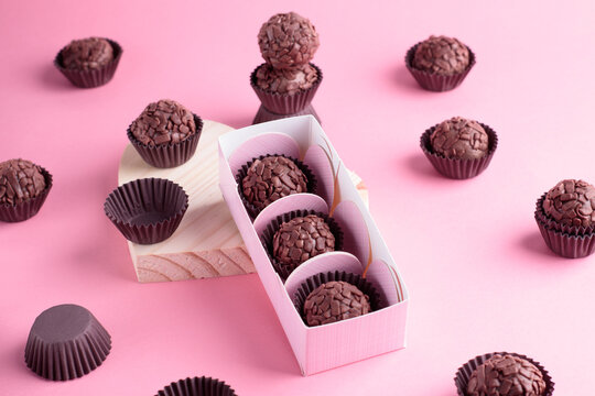 Brigadeiros e caixa de brigadeiro, fundo rosa