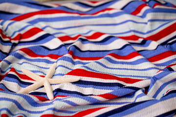 Bed linen surface at the resort. Close-up of soft multicolored wave patterns, fabric texture as background. Sea vacation, beach season. Towel on a sun lounger