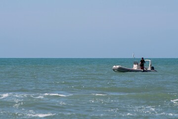 Person driving a motorboat in the middle of the sea