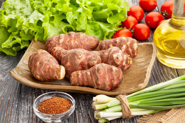 topinambur on a plate on wood background