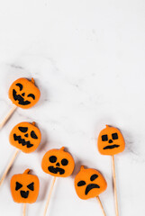 Themed Pumpkin jelly candies on a wooden stick. Halloween. Light background. Top view. Copy space