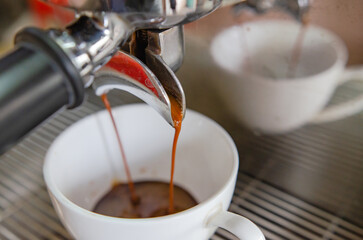 Barista making a cup of coffee soft focus image 