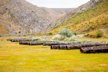 Construction and repair of the pipeline. Large metal pipes lie on the ground for installation and...
