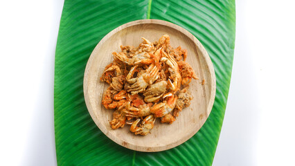 Fried crabs on wooden plate served on wooden plate and banana leaf. top view