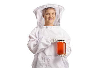 Young female bee keeper in a uniform holding a jar of honey and smiling