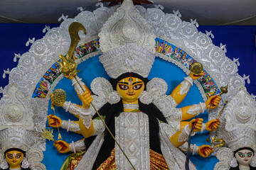 idol of goddess Durga during Durga Puja festival. Hindu deity in traditional white daker saj...