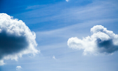 Naklejka na ściany i meble Summer sky. Cumulus clouds on a blue background. Partly cloudy.