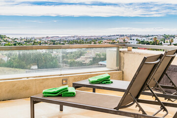 a view overlooking the Mediterranean coastline of the Costa Del Sol From the terrace of a luxury apartment complete with deck chairs close up