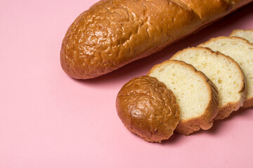 Bread product on a pink background. Sliced bread.