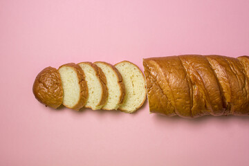 Bread product on a pink background. Sliced bread.