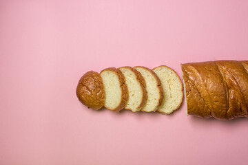Bread product on a pink background. Sliced bread.
