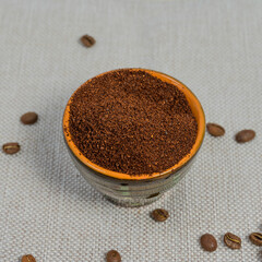 coffee beans, ground coffee in cups on a linen background