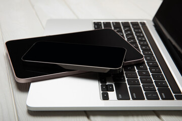 Open laptop with tablet and smartphone on white texture table.Mockup. Technology and electronics. Technology concept. Various gadgets.