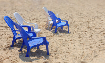 Fototapeta na wymiar Plastic chairs stand in the sand on a beach in Israel