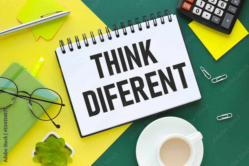 Poster think different. word on notepad with spring on green and yellow background